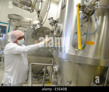 Darmstadt, Germania. Il 25 giugno, 2014. Rilasciate le foto dal chimico e farmaceutico società Merck KGaA mostra dipendente JOse Simoes in piedi in un granulatore in Merck Pharma la produzione in Darmstadt (Germania), 25 giugno 2014. Gli ingredienti della betablocker Concor vengono mescolati e granulati qui. Foto: ARNE DEDERT/dpa/Alamy Live News Foto Stock