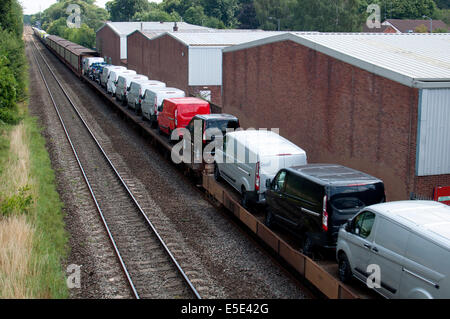 Il treno che porta nuova Ford furgoni Foto Stock