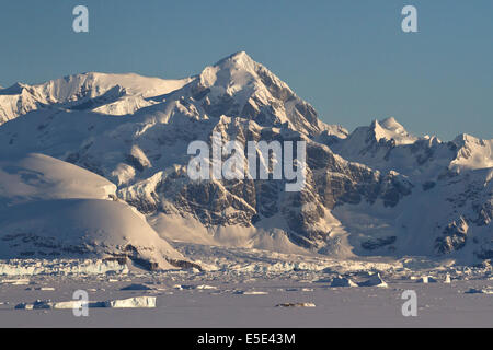 Montagne e oceano congelato con gli iceberg della Penisola Antartica Foto Stock