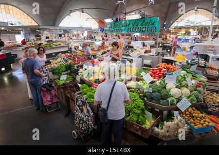 I clienti che comprano frutta e verdura dentro il mercato coperto a Royan Francia. Foto Stock