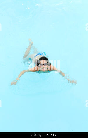 Un felice giovane donna in una piscina Foto Stock