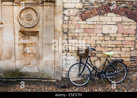 Una bicicletta parcheggiata fuori Gonville e Caius College in un giorno di pioggia nella città universitaria di Cambridge Regno Unito Foto Stock
