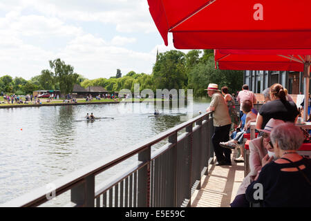 Teatro-frequentatori al RSC di guardare una regata di canottaggio sul fiume Avon a Stratford upon Avon, Warwickshire, Regno Unito Foto Stock