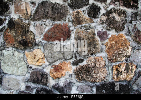 Sfondo parete testurizzata con insolite pietre di vari colori, forme e texture di dimensioni trovati in Antigua Barbuda nei Caraibi Foto Stock