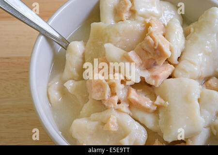 Molto vicino in vista del pollo e gnocchi di patate Zuppa in una ciotola con il cucchiaio su una tavola di legno alto. Foto Stock