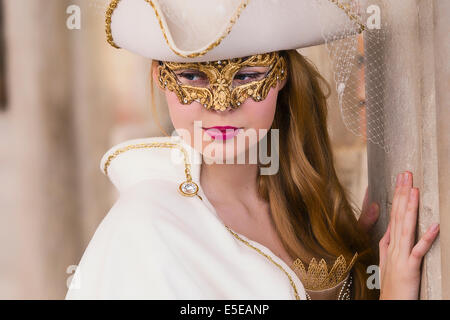 Bellezza adolescente in bianco costume rinascimentale celebra il Carnivale di Venezia al di fuori del Palazzo Ducale in piazza San Marco. Foto Stock