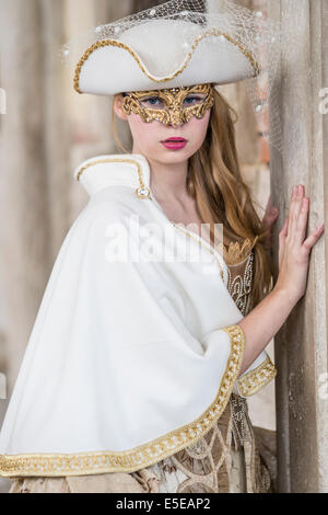 Bellezza adolescente in bianco costume rinascimentale celebra il Carnivale di Venezia al di fuori del Palazzo Ducale in piazza San Marco. Foto Stock