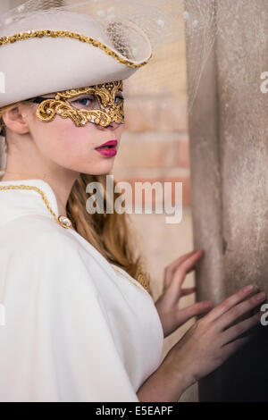 Bellezza adolescente in bianco costume rinascimentale celebra il Carnivale di Venezia al di fuori del Palazzo Ducale in piazza San Marco. Foto Stock