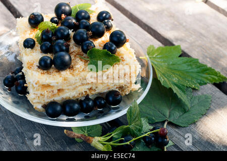 Berry torta di ribes nero con bacche e foglie su scrivanie di legno di close-up Foto Stock