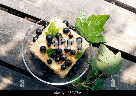 Berry torta di ribes nero con bacche e foglie su scrivanie di legno di close-up Foto Stock