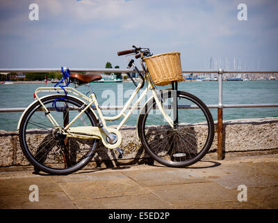 Una bicicletta appoggiata contro le ringhiere in riva al mare Foto Stock