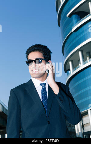 Indian business man con un telefono cellulare nel settore delle imprese di Nuova Delhi, India Foto Stock