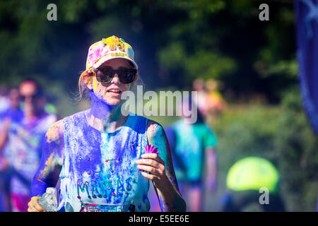 Giovane donna corre il colore Vibe 5K gara Foto Stock