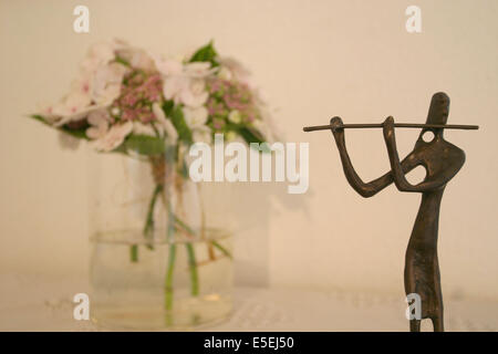 Francia, Normandia, manica, chambre d'hotes : montchaton, carrouge, statuette joueur de flute et bouquet de fleurs, Foto Stock