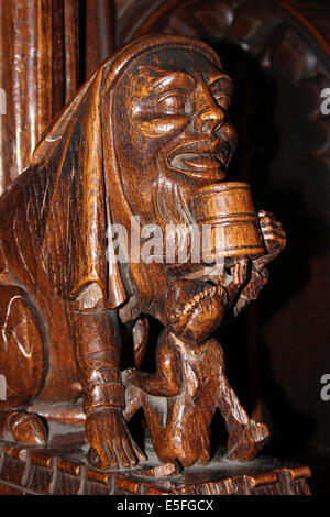 Scultura medievale in Chester Cathedral di un mezzo uomo mezzo cane carattere bere un il boccale di birra Foto Stock