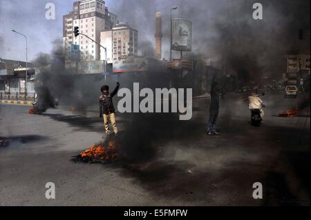 Sanaa, Yemen. Il 30 luglio, 2014. Yemenis bruciare pneumatici per protestare contro la decisione del governo di aumentare drasticamente il prezzo del carburante in Sanaa, Yemen, il 30 luglio 2014. Il governo yemenita ha aumentato il prezzo della benzina da 125 yemenita riyals (0,58 dollari USA) a 200 riyals per litro e disel da 100 riyals a 195 riyals Mercoledì, che ha scatenato proteste di massa nella capitale Sanaa. Manifestanti arrabbiati pneumatici bruciati e tagliato molte strade in Sanaa. Il governo ha distribuito più soldati per mantenere la sicurezza nella capitale. Credito: Mohammed Mohammed/Xinhua/Alamy Live News Foto Stock