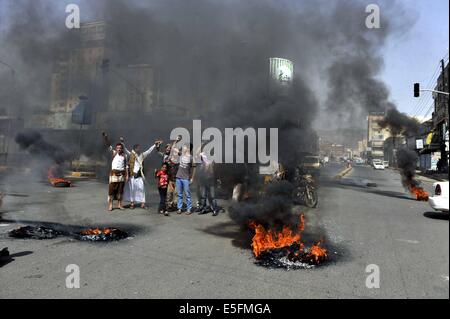 Sanaa, Yemen. Il 30 luglio, 2014. Yemenis bruciare pneumatici per protestare contro la decisione del governo di aumentare drasticamente il prezzo del carburante in Sanaa, Yemen, il 30 luglio 2014. Il governo yemenita ha aumentato il prezzo della benzina da 125 yemenita riyals (0,58 dollari USA) a 200 riyals per litro e disel da 100 riyals a 195 riyals Mercoledì, che ha scatenato proteste di massa nella capitale Sanaa. Manifestanti arrabbiati pneumatici bruciati e tagliato molte strade in Sanaa. Il governo ha distribuito più soldati per mantenere la sicurezza nella capitale. Credito: Mohammed Mohammed/Xinhua/Alamy Live News Foto Stock