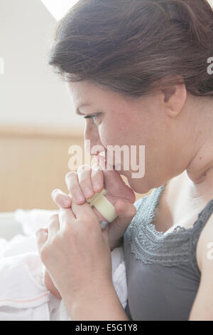 Madre baciare piedi del bambino (0-1 mese) Foto Stock