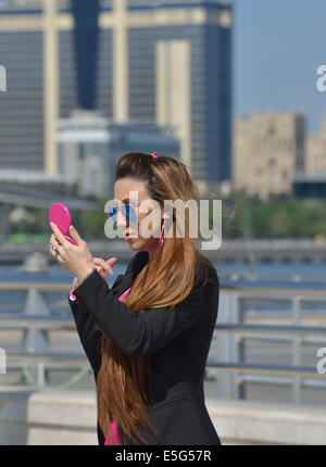 Giovane donna guardando in uno specchio, Baku, Azerbaijan Foto Stock