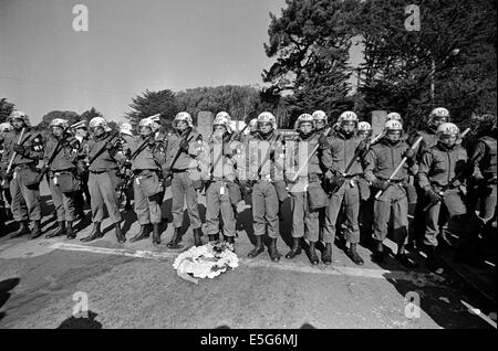 Anti-guerra di manifestanti giaceva un funerale corona ai piedi della polizia militare schierate per impedire ai dimostranti di entrare Presidio base navale di San Francisco, California. Foto Stock