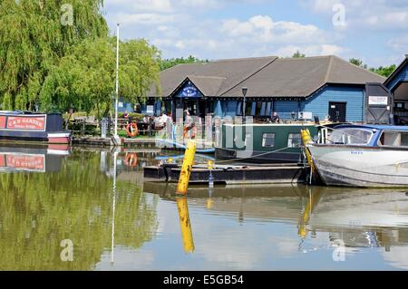 Narrowboats sulla loro ormeggi nel bacino del canale con una sala da tè cafe al posteriore, Barton Marina, Barton-sotto-Needwood, UK. Foto Stock