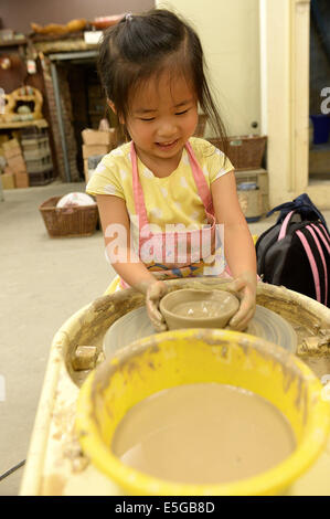 (140731) -- XINBEI, luglio 31, 2014 (Xinhua) -- Un bambino impara la produzione ceramica in Yingge Street di Xinbei City, a sud-est della Cina di Taiwan, 30 luglio 2014. La storia della produzione ceramica nel Yingge Street ha iniziato circa 200 anni fa, vari tipi di ceramiche fini qui prodotti attraggono molti turisti. (Xinhua/Egli Junchang) (whw) Foto Stock