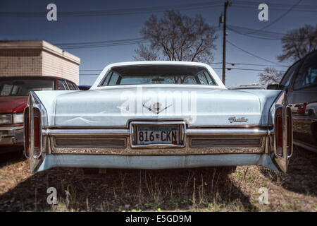 Il retro di un vecchio arrugginimento Cadillac, a sinistra in un cantiere di Minneapolis, Minnesota, Stati Uniti d'America. Foto Stock