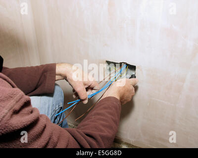 Prese elettriche con fili pronto per il cablaggio in una nuova proprietà o estensione con elettricista cablaggio in Foto Stock