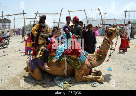 Di Karachi, Pakistan. 31 Luglio, 2014. I bambini preparano a cavalcare un cammello su l'ultimo giorno di Eid al-Fitr festival a Quetta, Pakistan, luglio 31, 2014. I musulmani in tutto il mondo celebra l'Eid al-Fitr, che segna la fine del mese di digiuno del Ramadan. Credito: Irfan/Xinhua/Alamy Live News Foto Stock