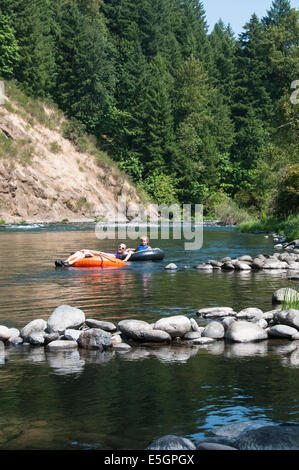 Un padre e daugher galleggiando giù il Nord Santiam fiume su innertubes in Oregon. Foto Stock