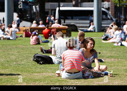 Le persone aventi il pranzo godendo le estati calde giorno nei motivi del Belfast City Hall nel centro della città Foto Stock