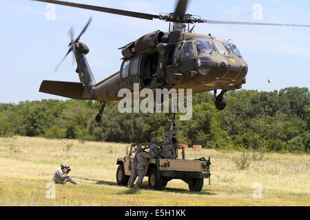 Stati Uniti Soldati gancio a gancio di carico pendente di rilascio per un UH-60 Black Hawk elicottero per imbracare il carico di un M-1097R1 Humvee, durante un fie Foto Stock