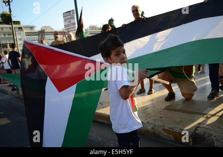 Atene, Grecia. 31 Luglio, 2014. Un giovane ragazzo detiene una grande bandiera della Palestina durante la protesta. L'ala sinistra parte fautori insieme con le persone dalla Palestina organizzare una dimostrazione di Atene a sostegno dello Stato di Palestina chiedendo la fermata del sangue. (Poto da George Panagakis/Pacific Press/Alamy Live News) Foto Stock