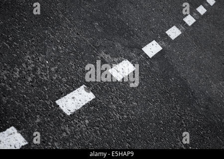 Dark strada asfaltata sfondo con strisce dividendo una linea di marcatura Foto Stock