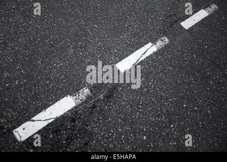 Asfalto nero su strada con sfondo striped dividendo una linea di marcatura Foto Stock