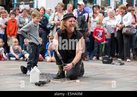 Street intrattenitore lavora con un piccolo ragazzo a Buchanan Street, Glasgow, Scotland, Regno Unito Foto Stock