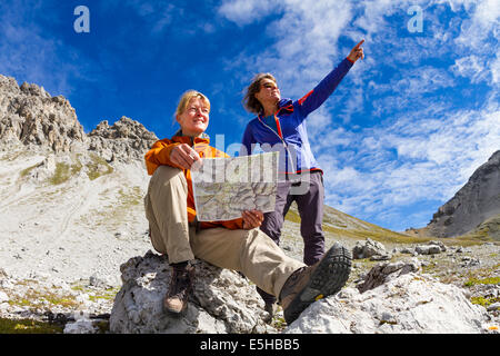Due donne che leggono la mappa dei sentieri, Val dal Botsch, Parco Nazionale Svizzero, Graubünden, Svizzera Foto Stock