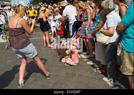 Donna che utilizza lo smartphone come fotocamera per fotografare bambini durante Whitstable Oyster Festival parade Kent England Regno Unito Foto Stock