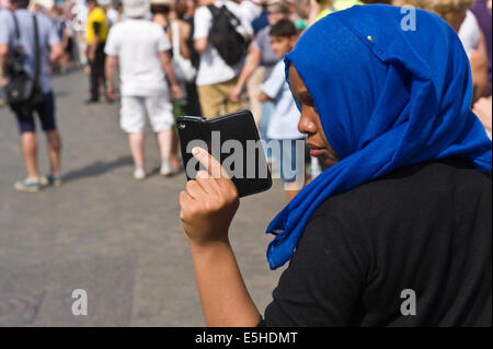 Donna che utilizza lo smartphone come fotocamera per fotografia Festival Oyster parade a Whitstable Kent England Regno Unito Foto Stock
