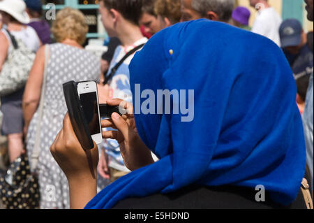 Donna che utilizza lo smartphone come fotocamera per fotografia Festival Oyster parade a Whitstable Kent England Regno Unito Foto Stock