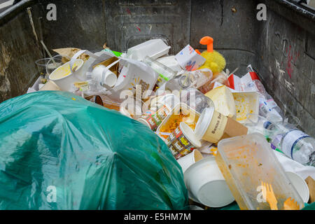 Una quasi completa dei rifiuti Rifiuti saltare cassonetto in postumi di una London Street Party festival concerto Leale fayre, UK. Foto Stock