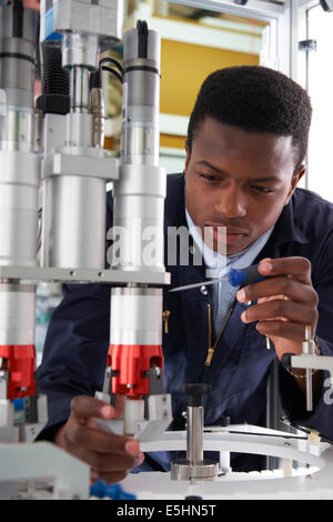 Apprendista ingegnere di lavoro sulla macchina in fabbrica Foto Stock