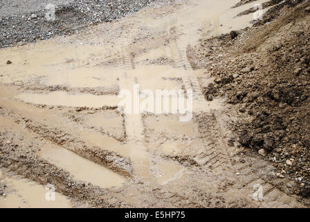 Tracce di pneumatici sulla sabbia, in prossimità di un cantiere con tracce di pneumatici, sabbia, sporco e pozzanghere Foto Stock