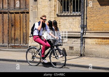 Ciclista passando Brasenose College lungo High Street, Oxford, Oxfordshire, Inghilterra, Regno Unito, Europa occidentale. Foto Stock