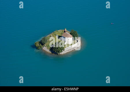 VISTA AEREA. Cappella su un'isola circondata da acque turchesi. Isola di Saint-Michel, Chorges, Lago di Serre-Poncon, Hautes-Alpes, Francia. Foto Stock