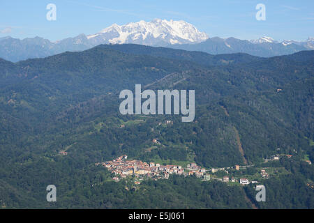 VISTA AEREA. Piccolo borgo di Arola con Monte Rosa (altitudine: 4634 metri) in lontananza. Provincia di Verbano-Cusio-Ossola, Piemonte, Italia. Foto Stock