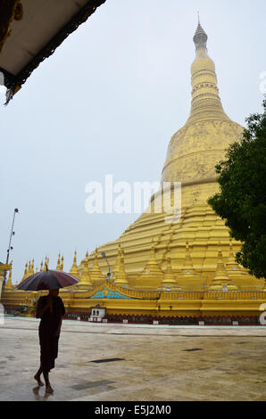 Buddista o Monaco a piedi a Shwemawdaw Paya Pagoda è uno stupa situato nel Bago, Myanmar in tempo di pioggia Foto Stock