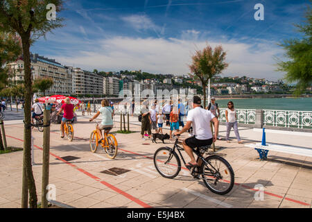 I turisti in bicicletta sulla pista ciclabile lungo la corniche, Donostia San Sebastian, Gipuzkoa, Paesi Baschi Foto Stock