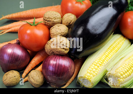 Freschi cibi crudi compresi melanzana, noci noci carote pomodori e mais per una dieta salutare concetto o Giornata Mondiale del Vegetarismo Foto Stock