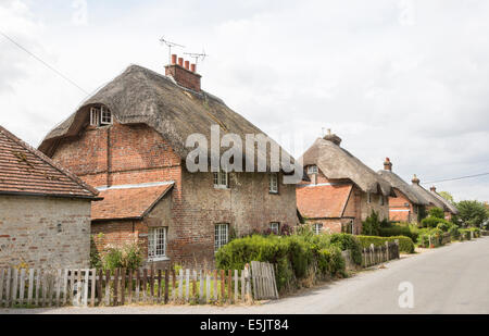 In mattoni tradizionali cottage con il tetto di paglia in Oriente Stratton, un piccolo paese di campagna vicino a Winchester, Hampshire, Regno Unito Foto Stock